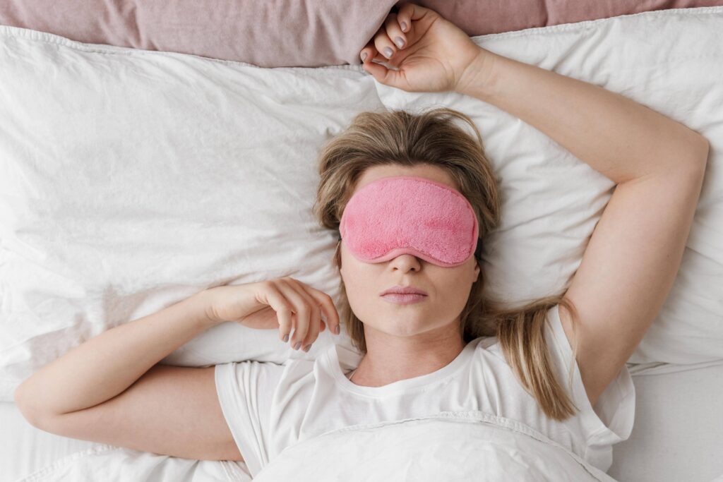 femme qui dort avec un masque de sommeil rose