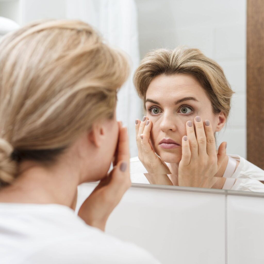 vieillissement peau prématurée visage femme se regardant dans miroir