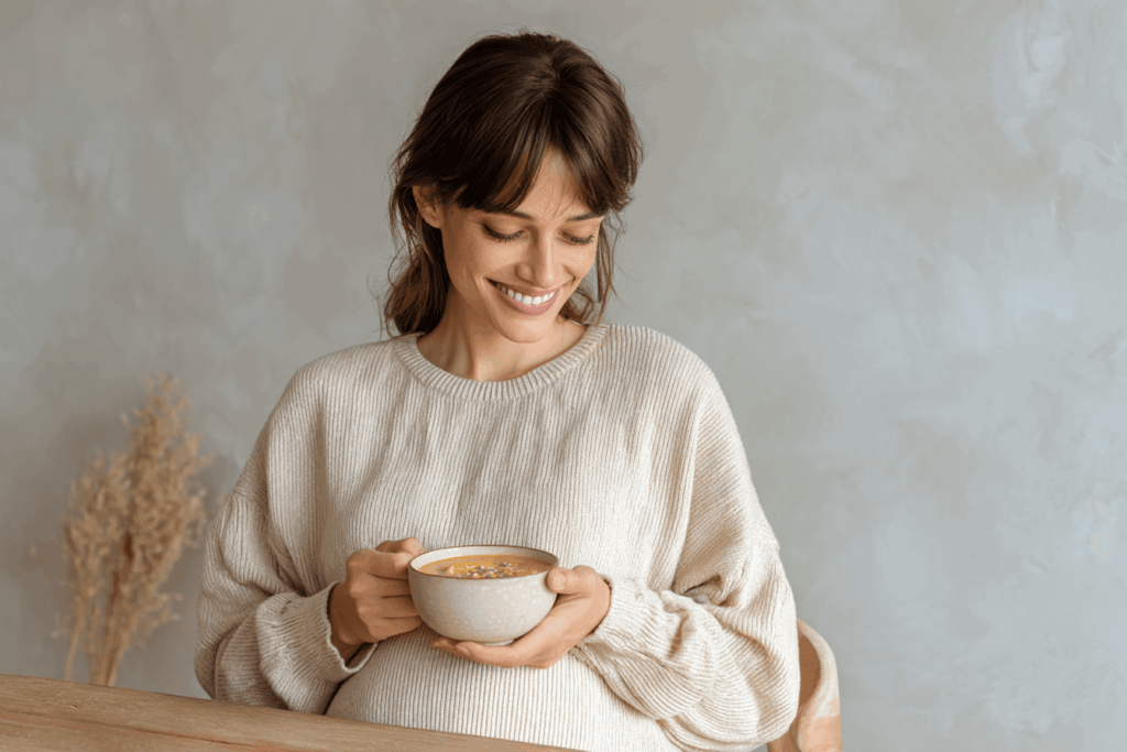 femme enceinte souriante en train de boire un bol de soupe faite à base de pâte de miso soupe de miso