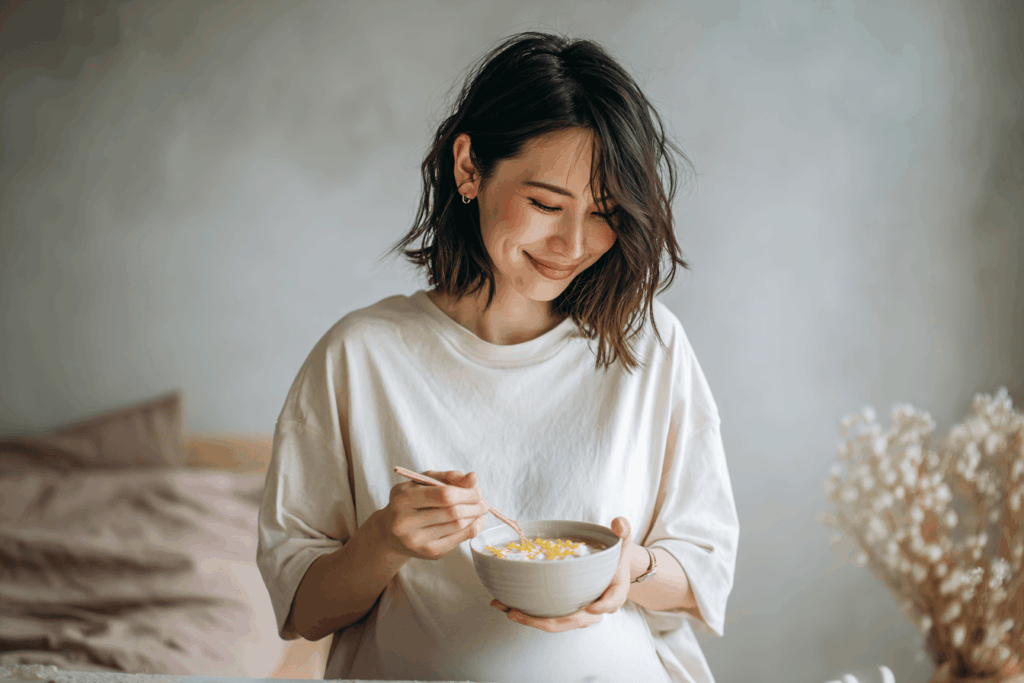 femme enceinte souriante en train de boire un bol de soupe faite à base de pâte de miso soupe de miso