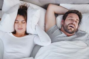apnée du sommeil et fatigue chronique femme portant un masque d'apnée du sommeil homme qui dort traitement de l'apnée du sommeil