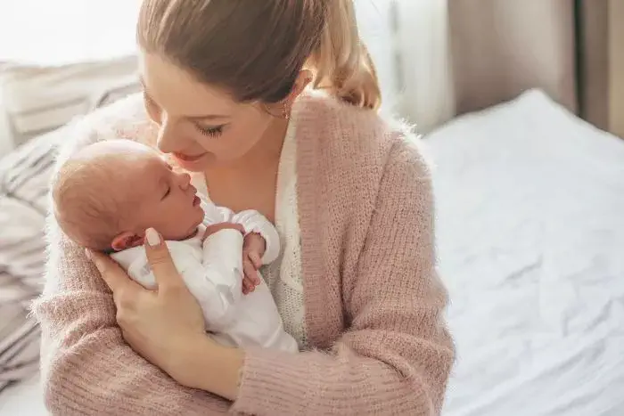 maman qui fait un calin à son nouveau né congé maternité
