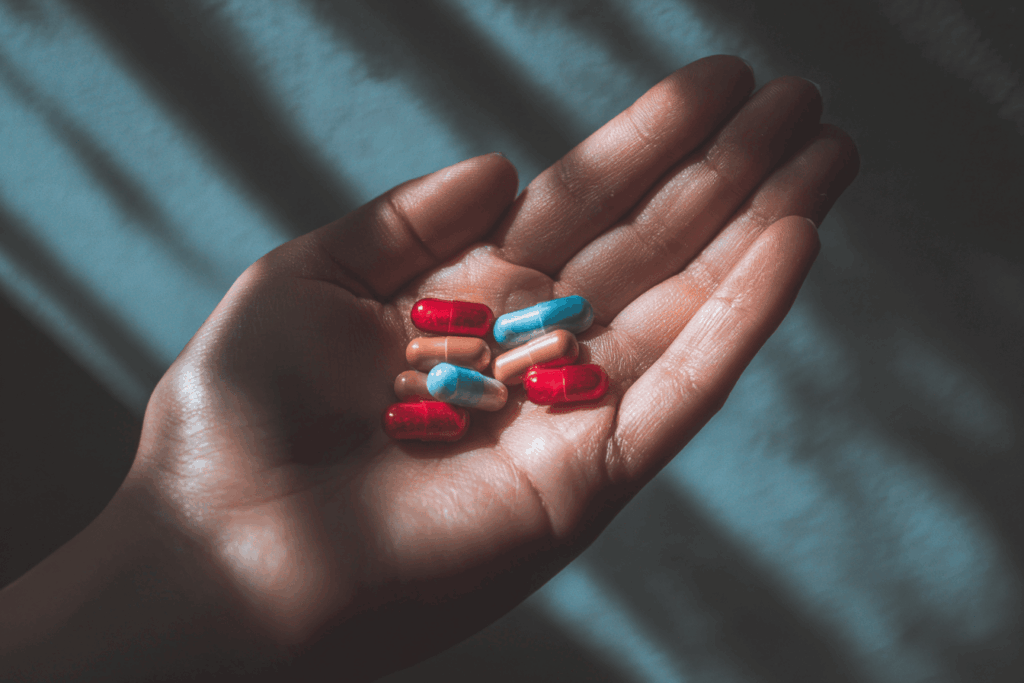 une main avec plusieurs médicaments de deux couleurs, lumière naturelle ambiance lumineuse rassurance style photo santé naturelle rendu réaliste haute définition