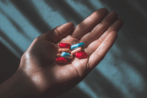 une main avec plusieurs médicaments de deux couleurs, lumière naturelle ambiance lumineuse rassurance style photo santé naturelle rendu réaliste haute définition